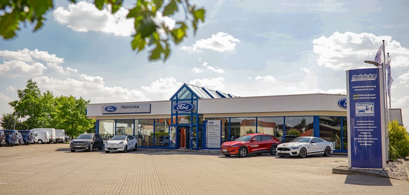 Das Autohaus Reinicke in Mücheln mit Ford-Schild, Glasfront und Fahrzeugen auf dem Hof